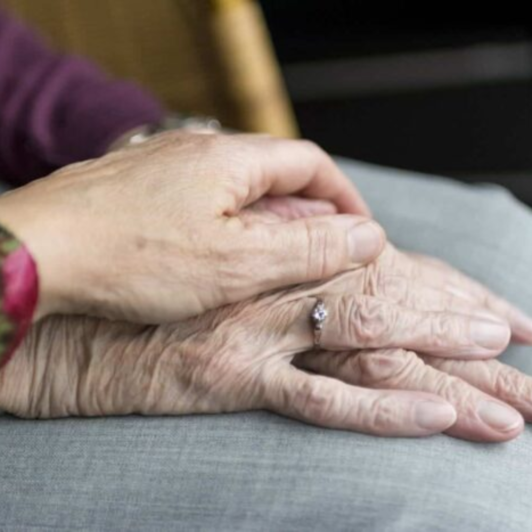 imagen de dos manos que se sostienen, aparentemente como muestra de apoyo, la mano de una mujer está agarrando desde arriba a la otra mano que también es de una mujer mayor