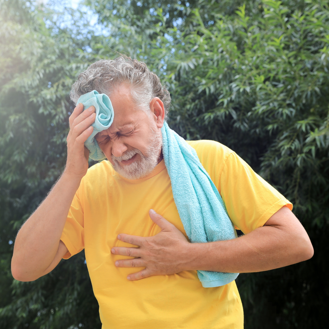 un hombre que aparentemente estaba ejercitándose, se seca el sudor de su cara con una toalla mientras de agarra el pecho con su mano y hace caras de fatiga y dolor. imagen de ejemplo de como puede afectarnos las olas de calor cuando no se toman las medidas necesarias
